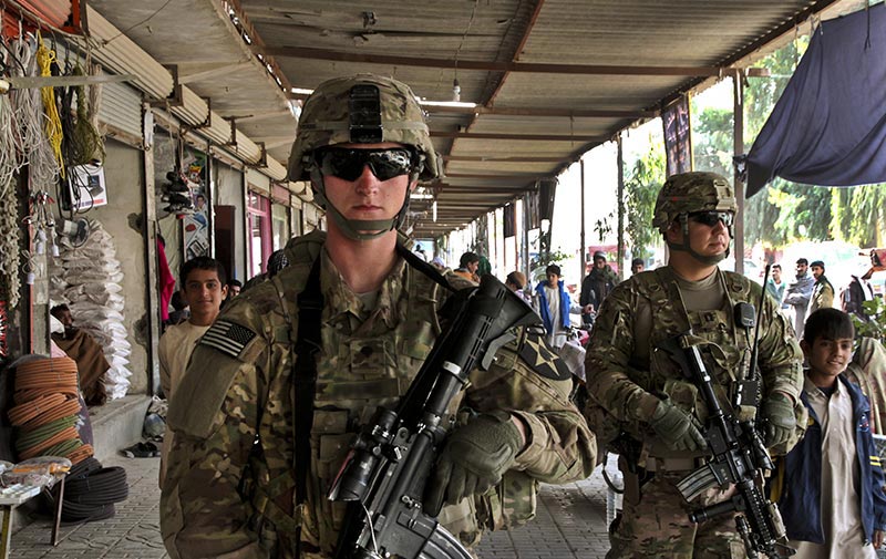 Soldiers walking through a marketplace where there are civilians