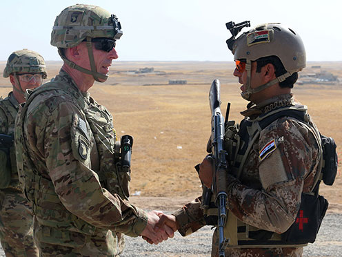 Commander speaking with a Soldier while shaking his hand