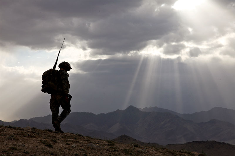 A Soldier on patrol on a mountain side