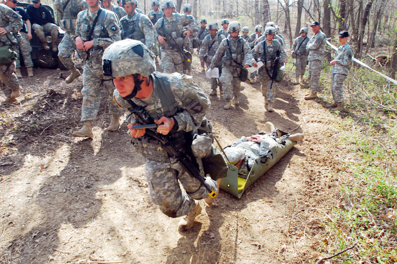 A Soldier maneuvering a casualty up a hill using a sled device