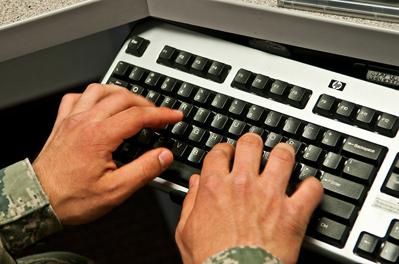 A Soldier types on a keyboard