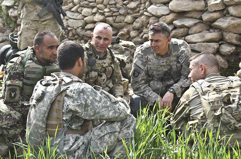 Soldiers sitting in a field having a discussion
