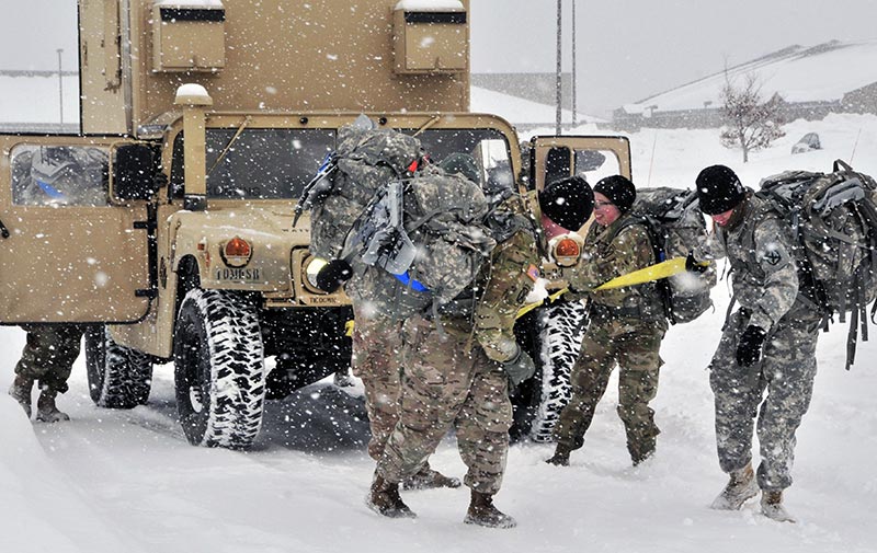 A team of officers works together to manually move a Humvee as part of a MuleSkinner Avalanche Challenge