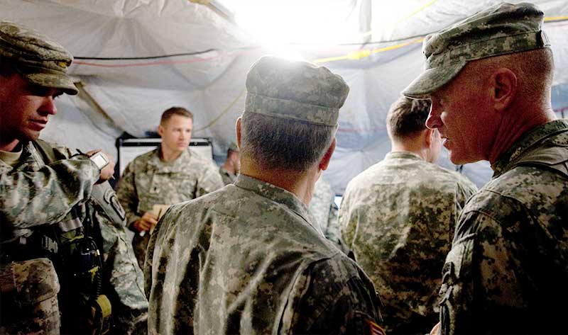 A group of Soldiers conduct a meeting in a tent