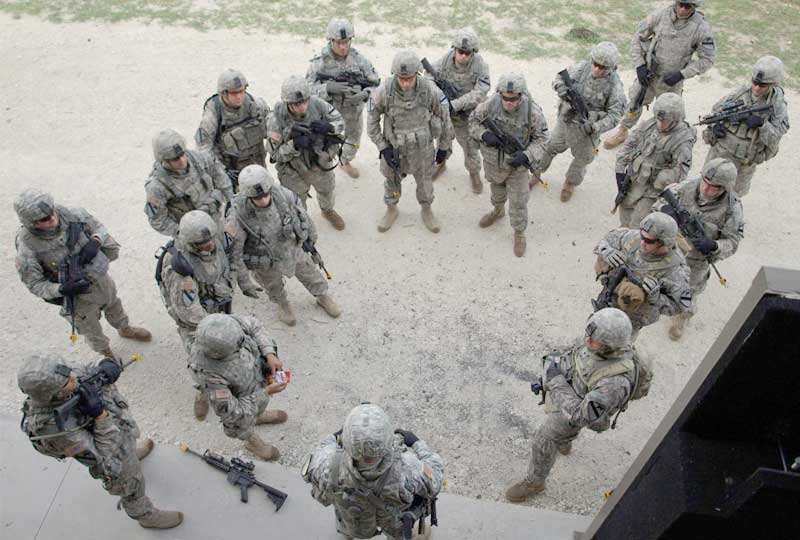 Soldiers standing in a circle talking as seen from above