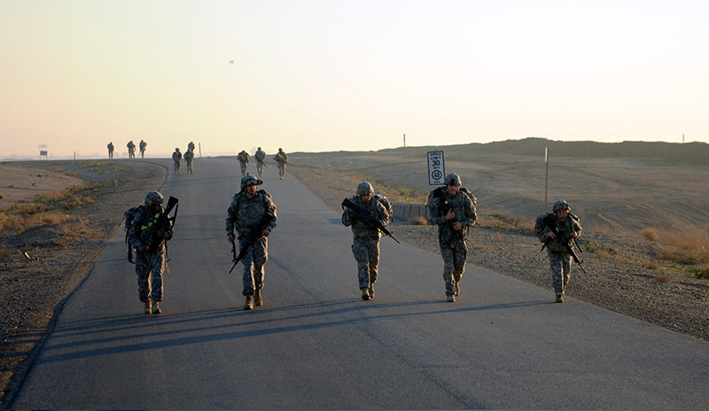 Four Soldiers walking along a street