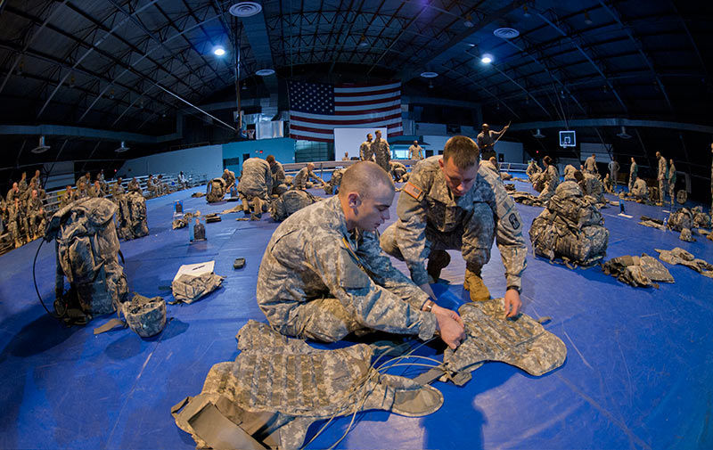 Two Soldiers assist each other with pre-combat checks