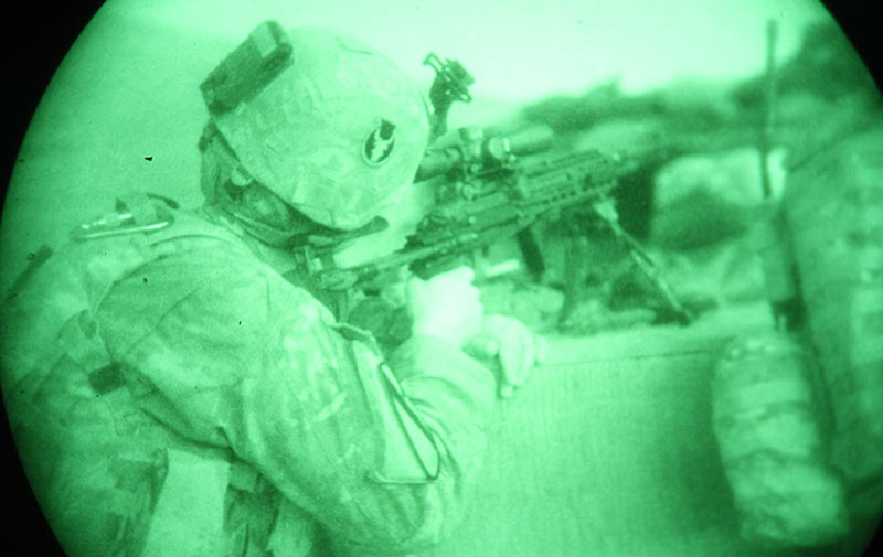 A Soldier looks down the sight of his gun at night