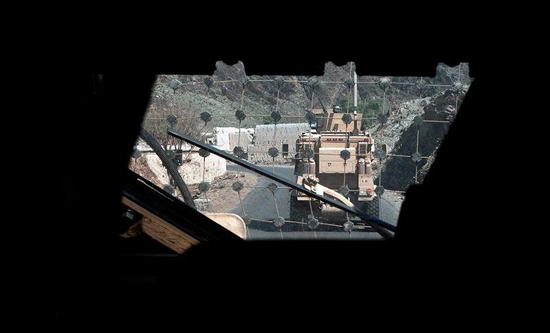 View of the back of a vehicle through the window of another truck