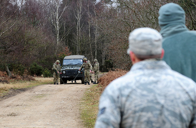 Soldier leader watching as subordinates conduct a vehicle check for I-E-Ds