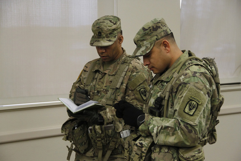 Two Soldiers look at notebooks