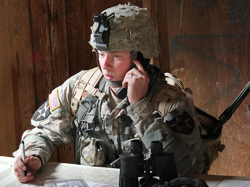 A squad leader transmits a call for artillery fire support