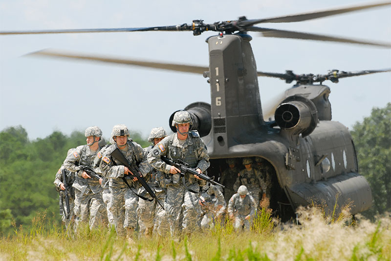 GSoldiers de-boarding a helicopter in a field