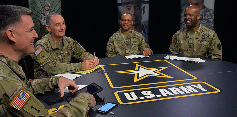 Sergeant Majors speaking with each other at a table during a training town hall