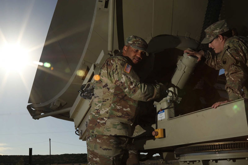 A Sergeant coaching a Soldier with an inspection of Warfighter Information Network Tactical system 