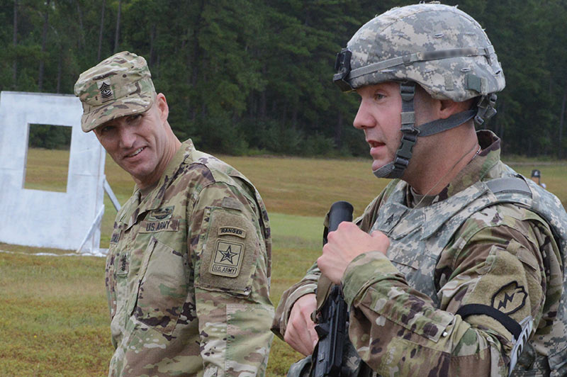 A sergeant major speaking with a Soldier who just finished a shooting even