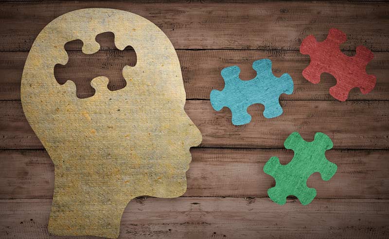 Human profile with different puzzle pieces