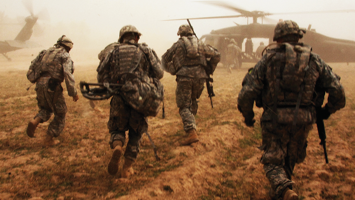 Soldiers running toward a helicoptor